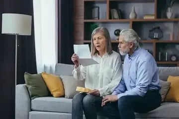 Shocked elderly couple looking at a letter