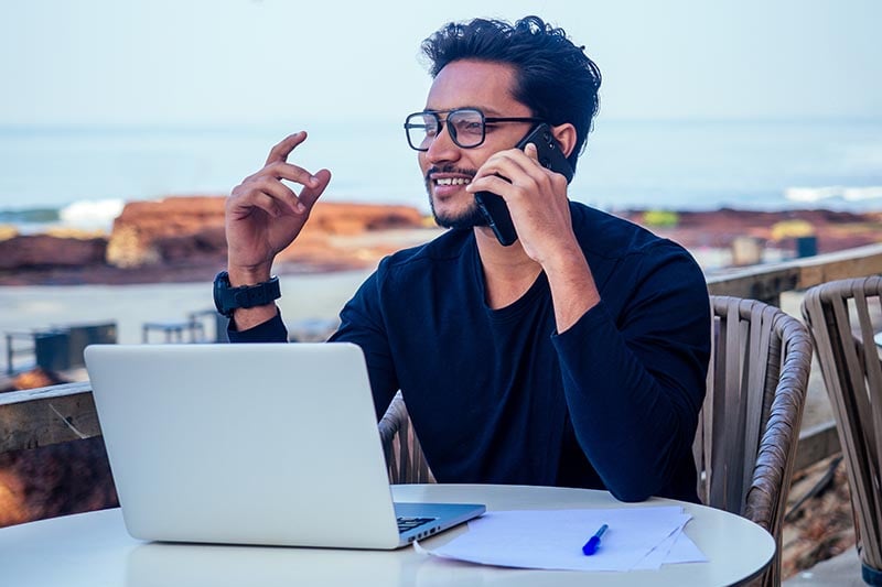 man on phone abroad with laptop