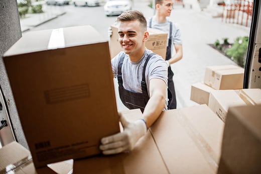 man smiling moving removals boxes from a va