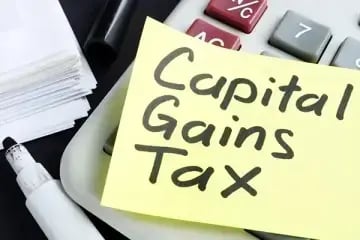 post it note with capital gains tax written stuck on a calculator